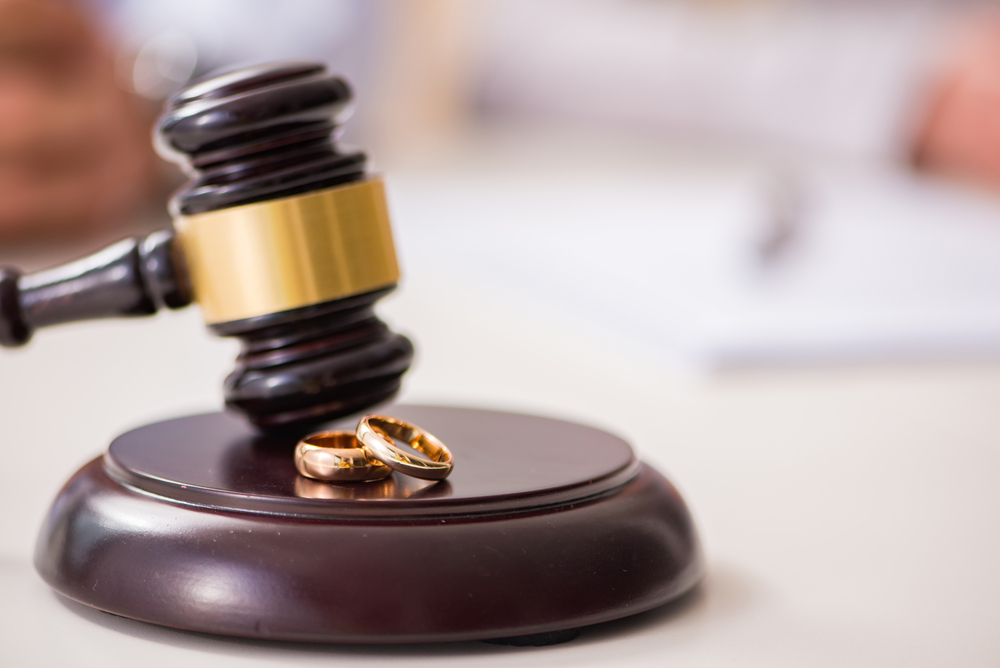 judge gavel with two gold wedding bands on top
