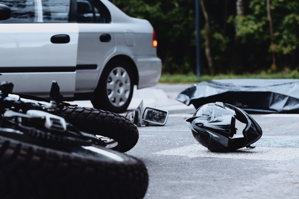 Motorcycle helmet and bike on the ground after accident with car
