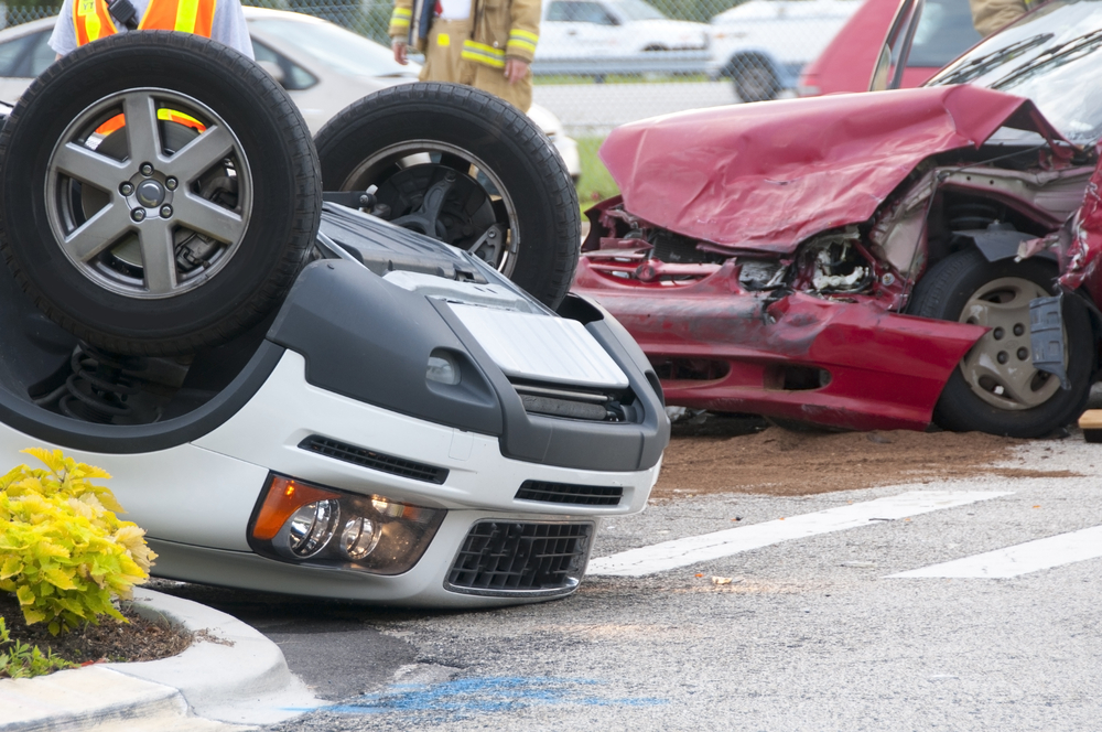 Car Accident Lawyer Kansas City, MO - white car rolled over red car front end damage road accident scene