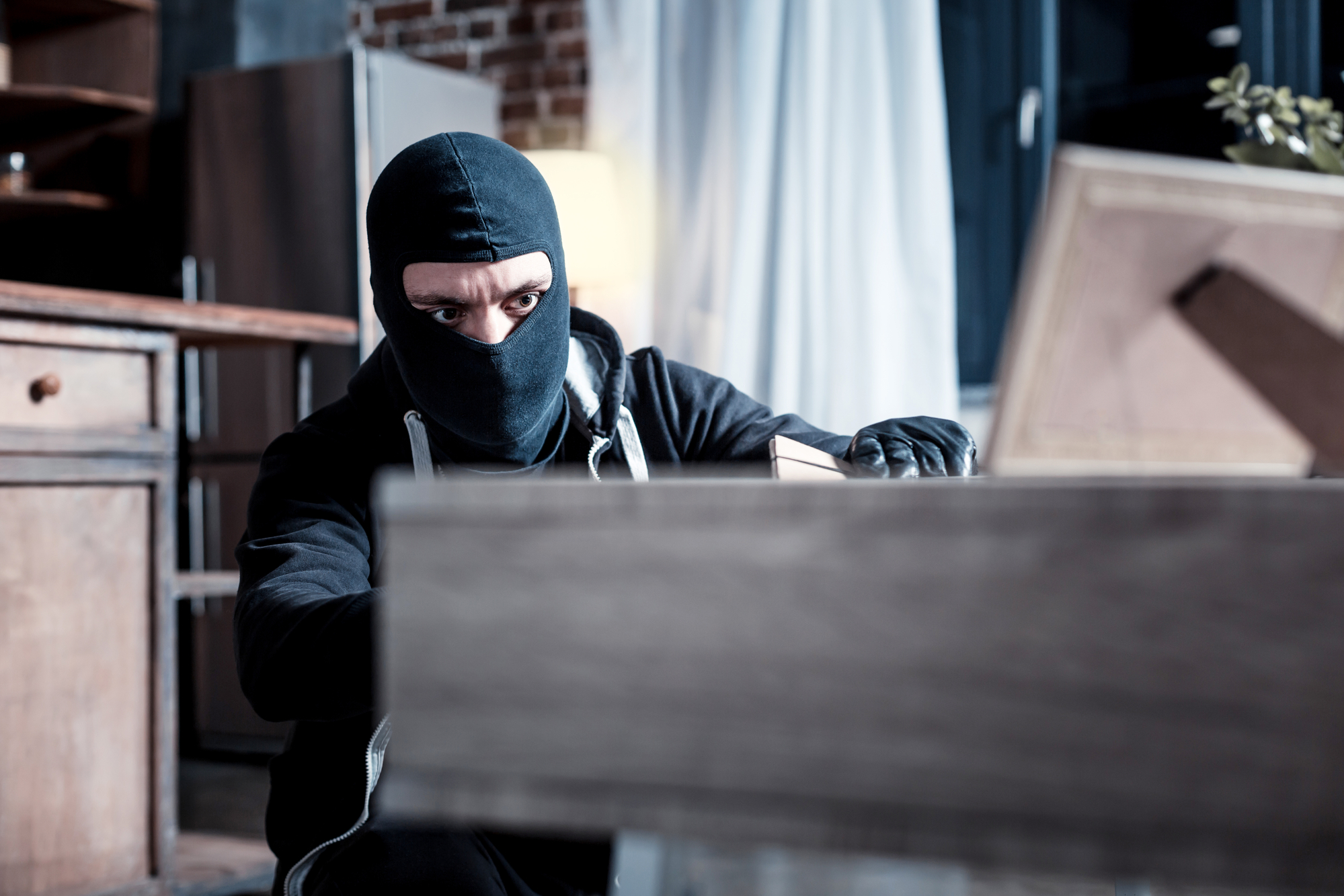 Steps To Take After Your House Was Robbed - Masked thief stealing important papers